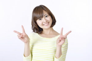 両手でピースサインをする女性