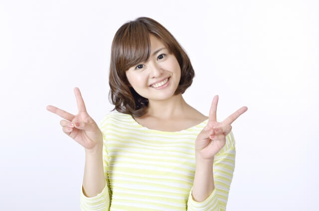 両手でピースする女性
