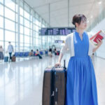 スーツケースを持って空港を歩く女性